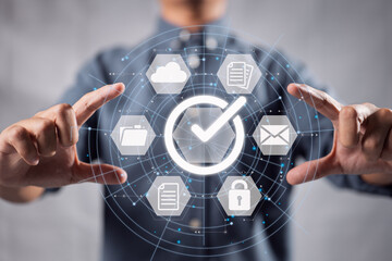 Leinwandbilder - A businessman holds a paper on a digital virtual screen and marks the relevant symbol.