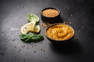 Poster - Fresh homemade organic dijon mustard in a bowl on black background, close up