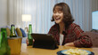 © ChayTee - Young happy attractive asia female enjoy relax night party event online celebration festive with friends at home sofa couch clinking beer with glass and bottle drinking via online video call.