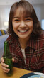 © ChayTee - Selfie view of young happy attractive asia woman enjoy relax night party event online celebration festive with friends at home clinking beer cheers with bottle toasting drinking via online video call.