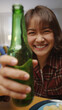 © ChayTee - Selfie view of young happy attractive asia woman enjoy relax night party event online celebration festive with friends at home clinking beer cheers with bottle toasting drinking via online video call.