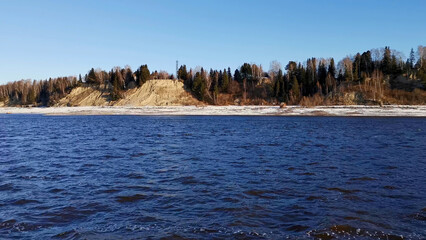 Poster - Landscape with a river. Clip. A spring frozen river with a view of which you can see frozen forests and grass and a bright morning sky.