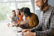 © yurolaitsalbert - variety of employees sitting at a desk in a coworking center.
