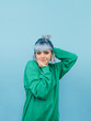 © bodnarphoto - Cute hipster girl with colored hair isolated on blue background, looking at camera and posing. Vertical