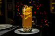 Orange grog in a tall glass stands on the bar