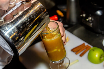 The bartender at the bar prepares orange grog