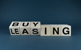 Fototapeta Zachód słońca - Leasing vs buy. Cubes form the choice words leasing or buying.