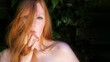 © ullision - Sensual, seductive wide banner portrait of beautiful red-haired woman outdoors with ivy background and green leaves, with finger and sexy lips oral sensuality