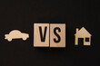 Wooden symbols, blocks on the black background versus house and car