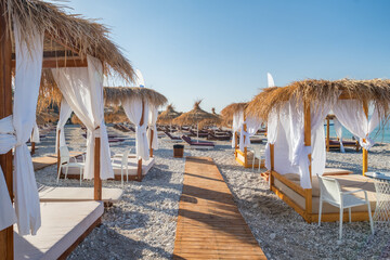 Wall Mural - Canopy beach bed with white curtains on an empty beach in summer