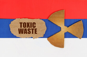 On the flag of Russia, the symbol of radioactivity and torn cardboard with the inscription - Toxic waste