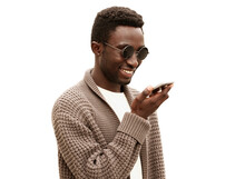 Portrait Of Smiling Young African Man Holding Smartphone Using Voice Command Recorder, Assistant Or Takes Calling, Looking At Phone Isolated On White Background