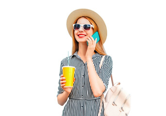 Wall Mural - Portrait of happy smiling woman calling on smartphone with cup of juice wearing straw hat, backpack isolated on white background