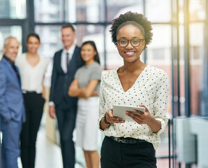 Poster - Shes leading the team on their embark to success. Portrait of a young businesswoman holding a digital tablet with her colleagues in the background.
