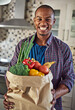 Ive started to eat healthier. Cropped portrait of a handsome young man holding a bag of groceries in the kitchen at home.