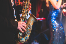 Concert View Of A Saxophonist, Saxophone Sax Player With Vocalist And Musical During Jazz Orchestra Performing Music On Stage
