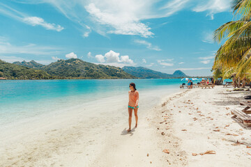 Wall Mural - French Polynesia Travel beach picnic motu tour on Huahine, Tahiti, French Polynesia. Happy tourist woman walking on perfect beach living healthy lifestyle