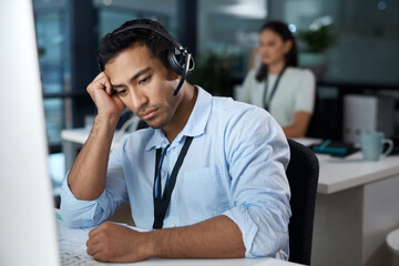 Poster - I need support too. Shot of a young man using a headset and looking depressed in a modern office.