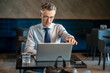 © zinkevych - A businessman working on a laptop in a cafe