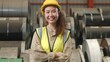 Asian industrial woman curly hair engineer standing wearing safety uniform with hardhat smiling and arms crossed in metal sheet factory production manufacture workshop, Happy female worker