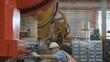 Engineer or operator wearing a safety suit working bending metal sheet by sheet press bending machine in workshop, Worker in factory at metal folding machine putting work piece at factory industry