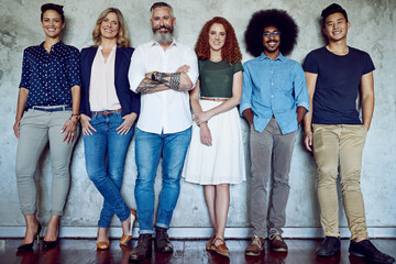 Poster - Were in line to our next big success. Portrait of a group of designers standing against a wall in an office.