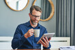 © Nola Viglietti/peopleimages.com - Luckily the coffee is tasting good today. Shot of a focused middle aged businessman browsing on a digital tablet while enjoying a cup of coffee at home during the day.