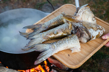 Fish soup prepared over an open fire. Cooking fish soup over an open fire in a kettle. Cooking in hiking tourism and fishing