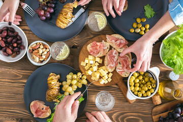 Wall Mural - Top view of three people having dinner together on rustic wooden table. Friends having dinner concept