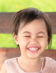 Wall Mural - Portrait of four years old happy laughing Asian girl, little preschooler child.