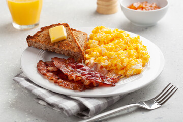 traditional scrambled egg breakfast with bacon and toast