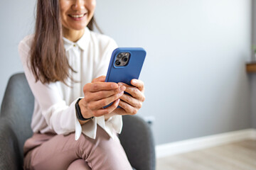 Businesswoman using smarphone indoors, copy space. Close up of a woman using her smartphone indoors. Cropped shot of a businesswoman using a mobile phone in a modern office