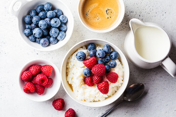 Poster - Rice pudding with berries and butter. Porridge bowl with raspberries and blueberries.