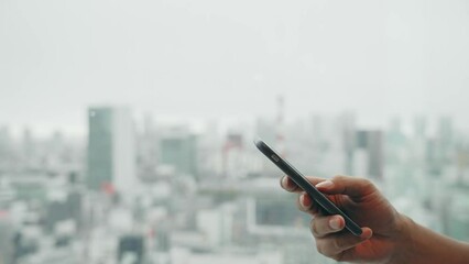 Poster - 都市を背景にスマホを使う男性