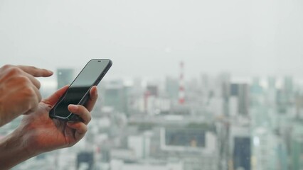 Poster - 都市を背景にスマホを使う男性