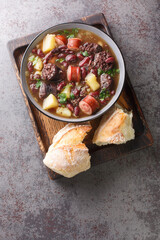 Wall Mural - Sopa da Pedra Portuguese Stone Soup closeup in the plate on the table. Vertical top view from above