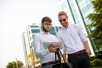 Sticker - Two successful business men walking outdoors. Business, friendship, communication concept