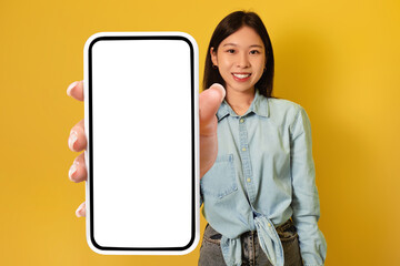 Poster - Young Asian lady showing big smartphone with mockup, promoting app or website, advertising product or service