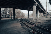 Abandoned Railway Under A Concrete Overpass. Old Rails Under The Road Bridge