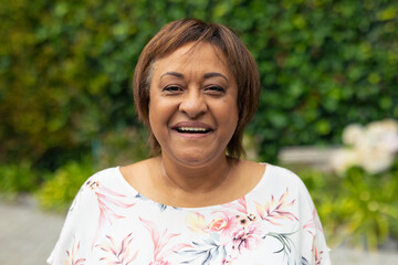 Portrait of happy african american senior woman with short brown hair standing outdoors