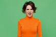 Young sad dissatisfied indignant displeased outraged woman 20s in casual orange turtleneck look camera isolated on plain pastel light green color background studio portrait. People lifestyle concept
