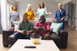© WavebreakMediaMicro - Happy multiracial senior male friends playing video game while women in background at home