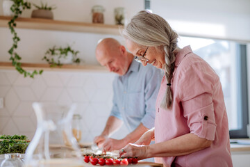 Wall Mural - Happy senior couple cooking together at home.