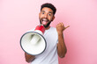 canvas print picture Young Brazilian man isolated on pink background shouting through a megaphone and pointing side
