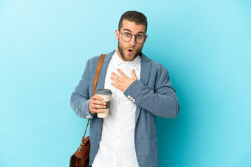 Wall Mural - Young caucasian businessman isolated on blue background surprised and shocked while looking right