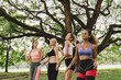© gumpapa - happy young multiethnic women teenager friend group relaxing and dancing after exercise in the park at weekend morning. young people lifestyle concept.