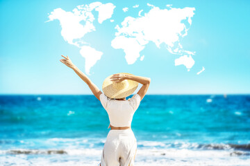 Wall Mural - Conceptual photo of a women wearing straw hat, enjoying sunny time at the beach. Back view. World map shaped clouds in the blue sky. Travel. Tourism.