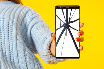 Poster - A broken smartphone screen. Replacement of the smartphone screen. Equipment repair service. The girl shows a mobile phone with a cracked screen. Orange background.