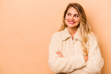 Wall Mural - Young caucasian woman isolated on beige background smiling confident with crossed arms.