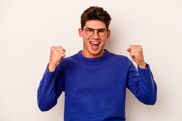 Young caucasian man isolated on white background cheering carefree and excited. Victory concept.